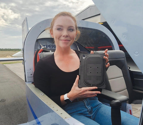 Flight instructor, Erin Douglas holding her iPad mini 6 in the Cooling Case and looking pleased