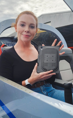 Erin Douglas (Flight Instructor) sitting in her plane and holding up the iPad mini 6 Cooling Case