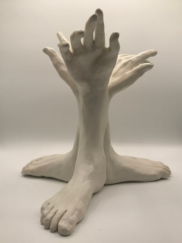 clay sculpture of three hands growing out of three feet.