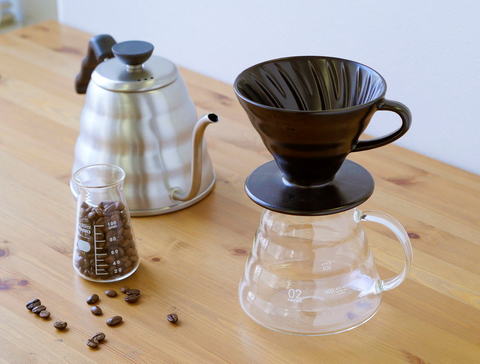 V60Coffee Dripper above a carafe along with a Gooseneck kettle