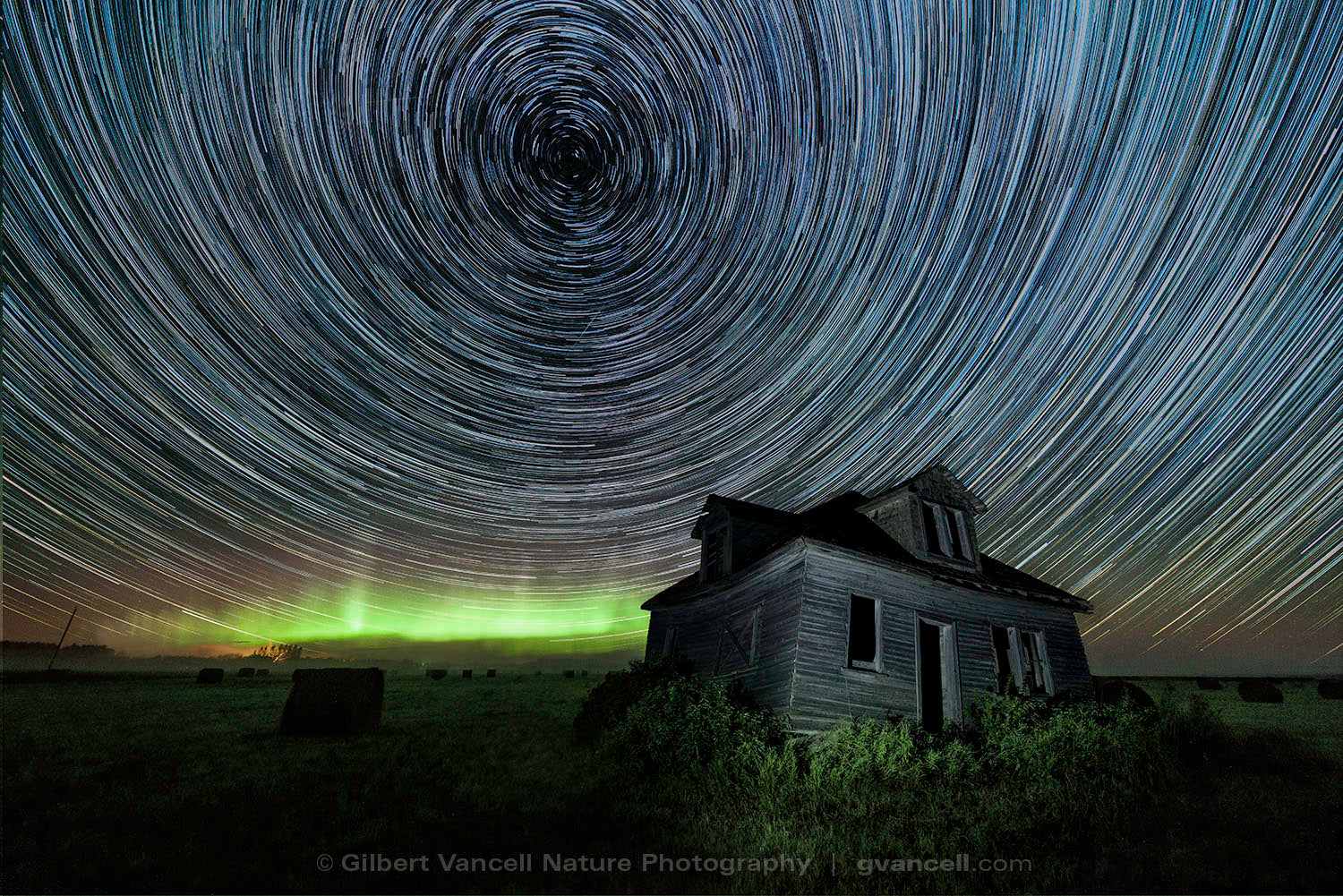 Star trails over abandoned farmhouse, with the Aurora on the horizon. Arborg, Manitoba – Canada