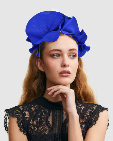 model wearing the ford millinery poppy headpiece in blue