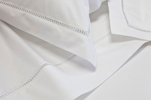 Luxury white bed linen close up with ladder stitch detail