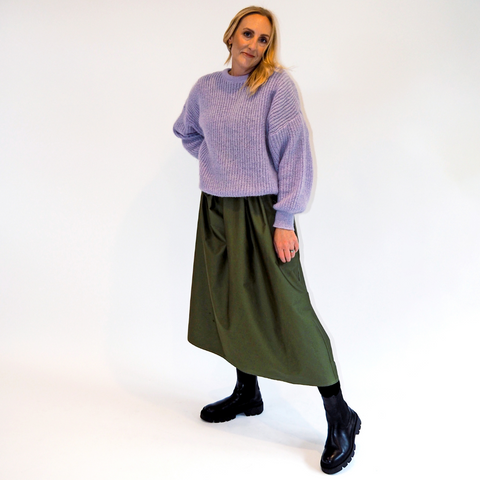 Ames Store - model wearing a lilac wool jumper green skirt black boots