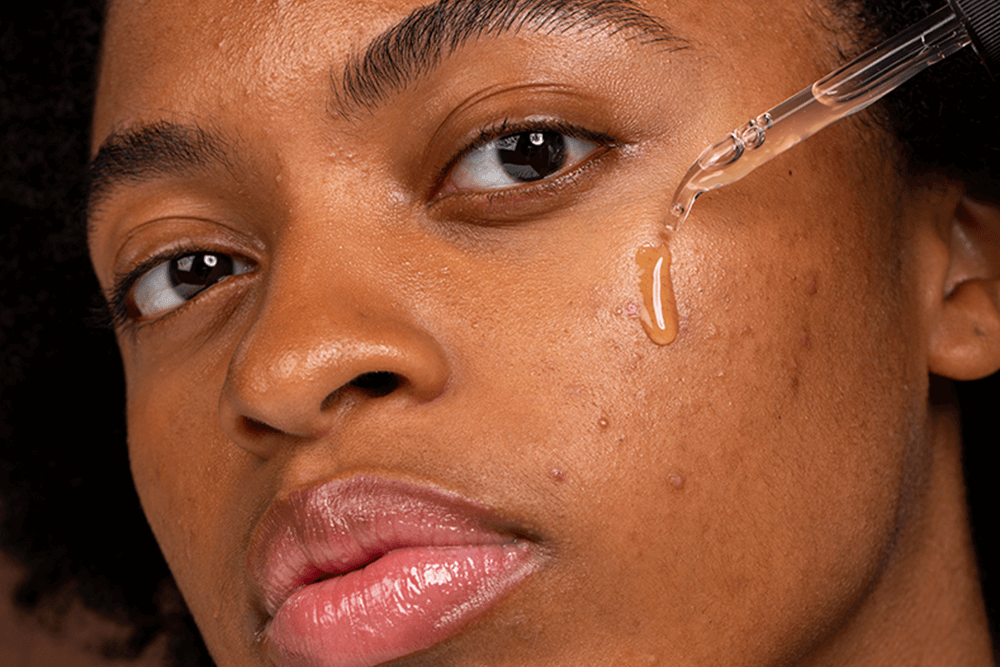 Woman applying retinol serum on her face