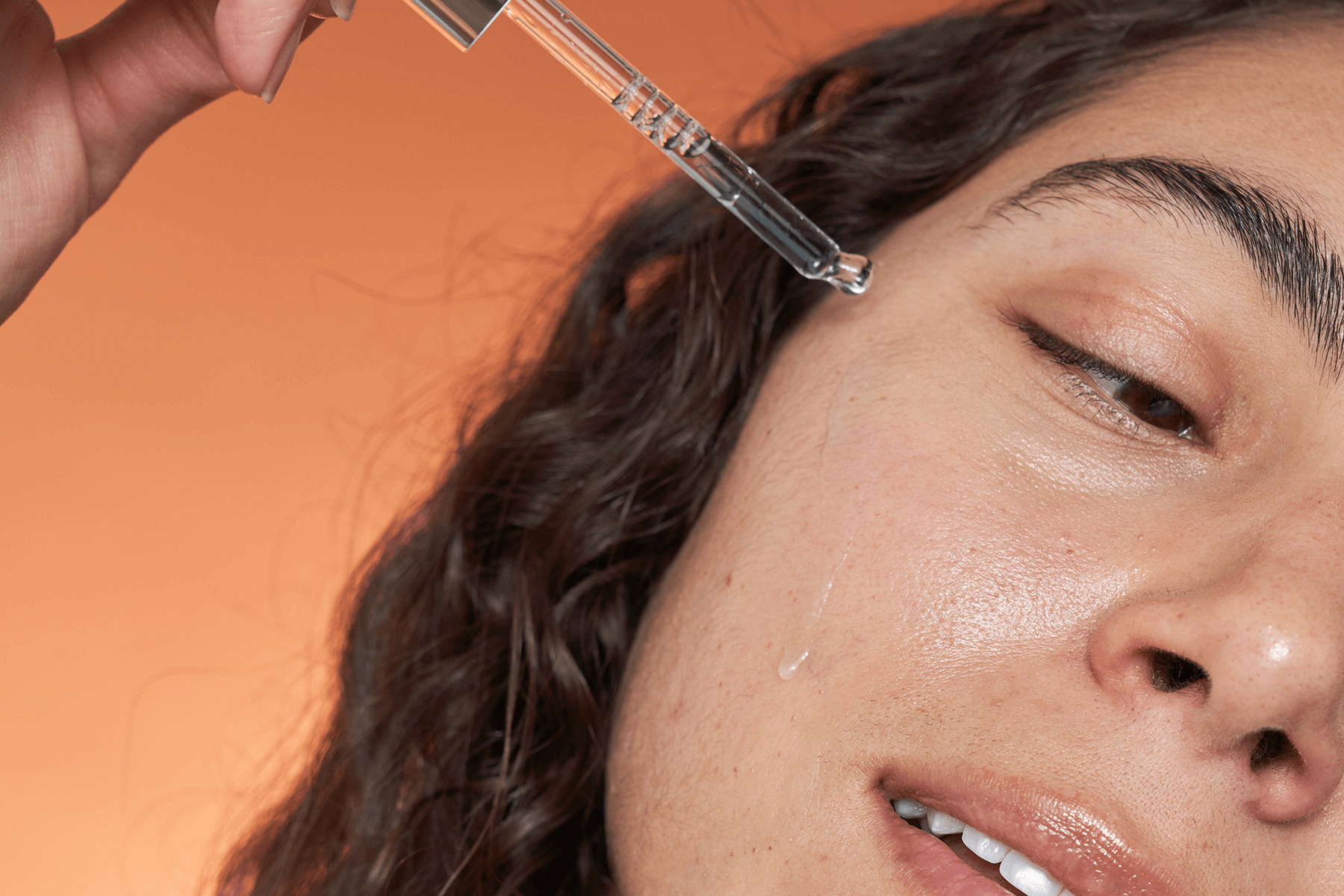 A girl applying hyaluronic acid serum with a dropper