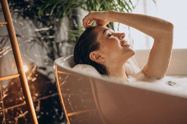 Smiling woman relaxing in a bath tub
