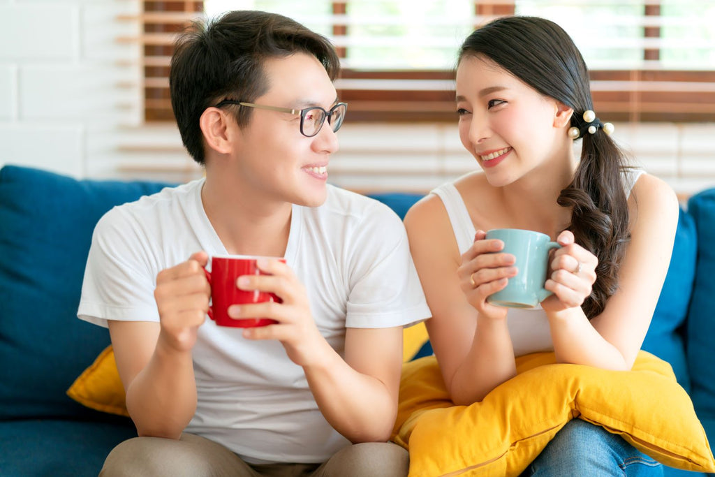 Happy couple drinking from mugs