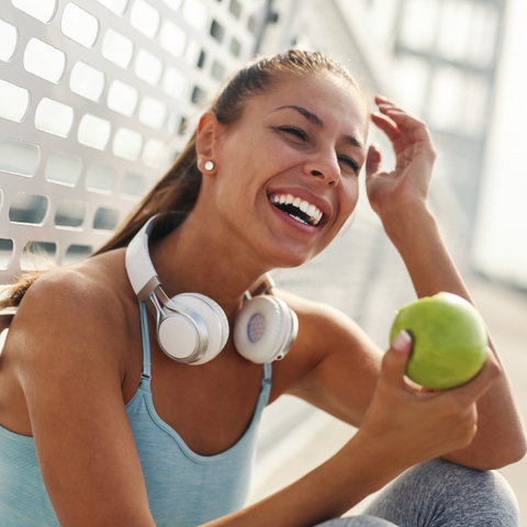 Women smiling with a fruit on her hand