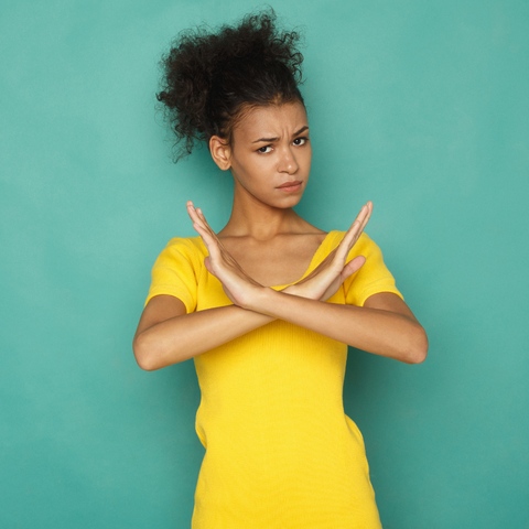 Image of women symbolically showing NO with her hands crossed