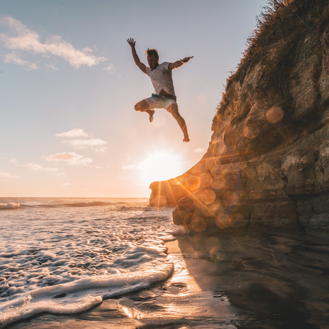 man jumping on beach