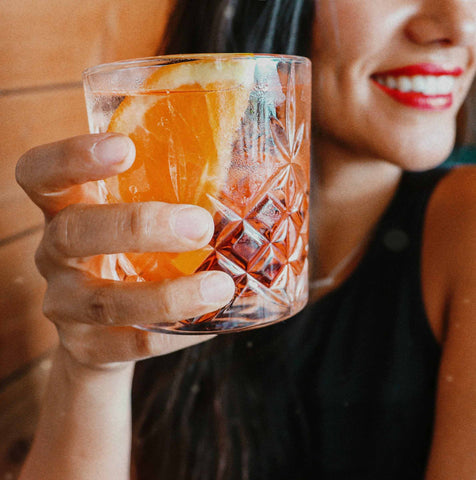 Woman holding a cocktail in a rocks glass