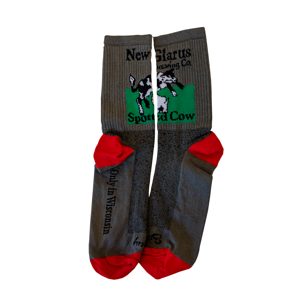 Gray socks with the New Glarus Brewing Co. Spotted Cow logo in black, white and green. The heels and toes of the socks are red.