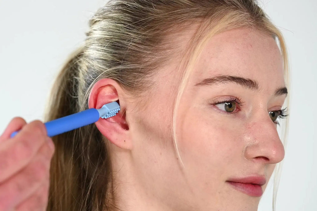 Woman massaging her ear with the ARK Z-Vibe