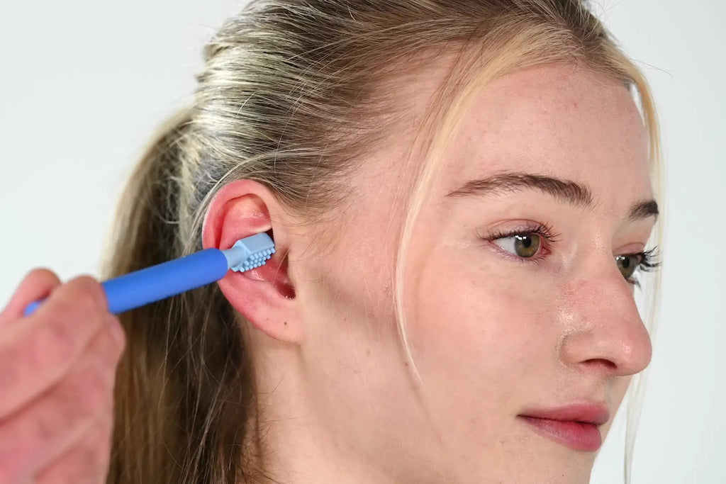 Femme se massant l'oreille avec l'ARK Z-Vibe