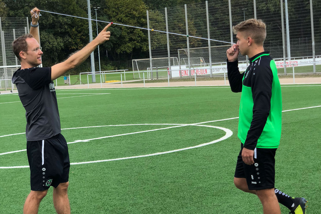 Neuroathletiktrainer Dominik Suslik trainiert einen Nachwuchsspieler mithilfe eines Brock Strings.