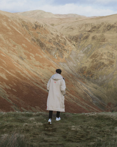 A guy in an outdoor Robe in the mountains 