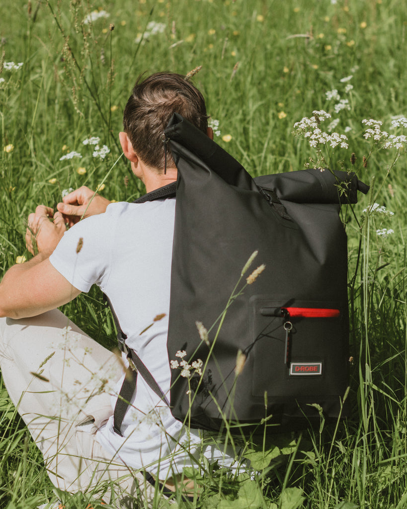 Image of the midnight black roll-top rucksack, crafted from TPU - a durable, waterproof, recyclable and biodegradable material.