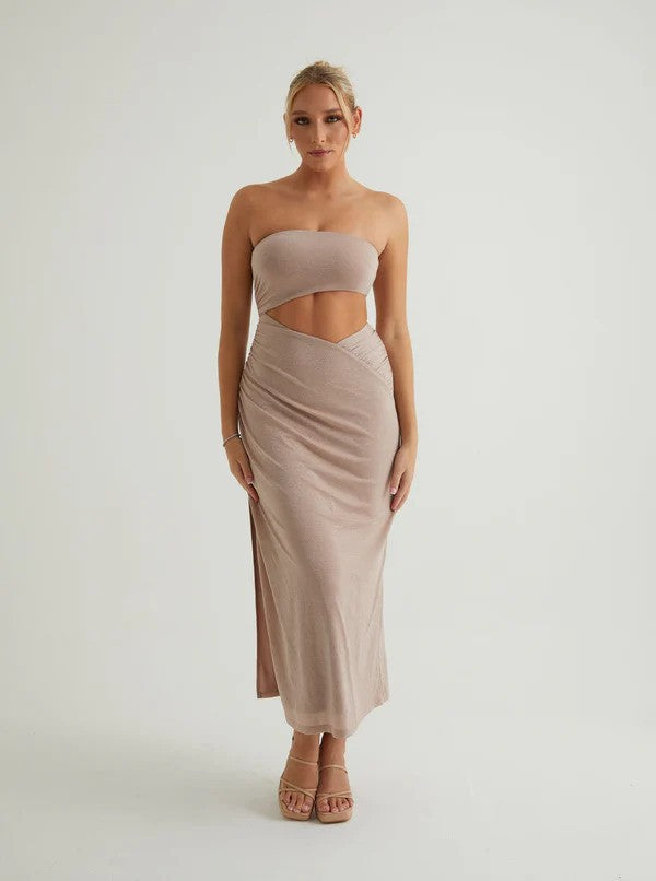 A woman wearing a beige-gray tube dress with a cut-out at the waist