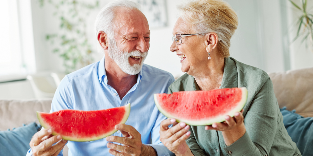 Older couple enjoying two watermelon slices
