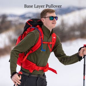 man backcountry skiing wearing green alpaca wool base layer pullover