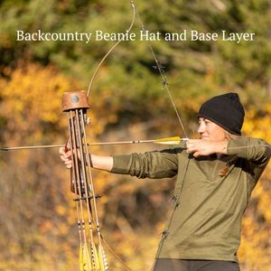 woman bow hunting wearing green alpaca wool base layer and black alpaca wool backcountry beanie