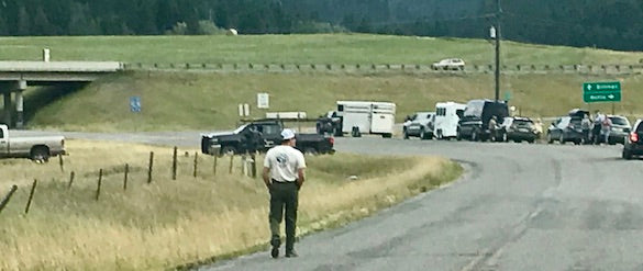 man walking down road towards horse trailers and trucks