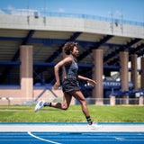 woman running on a track wearing black and red alpaca wool mid crew socks