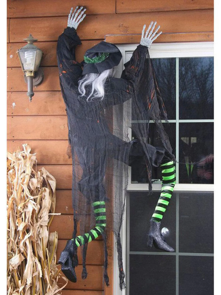 A Halloween decoration that looks like a witch climbing a wall.