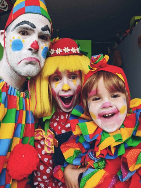 A family dressed in colorful clown Halloween costumes.