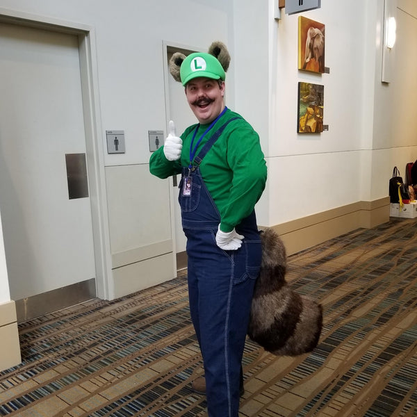 A man wearing a DIY Luigi Halloween costume with Raccoon ears and tail.