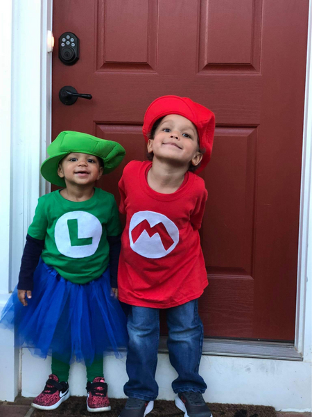 Two young children wearing homemade Mario and Luigi Halloween costumes.