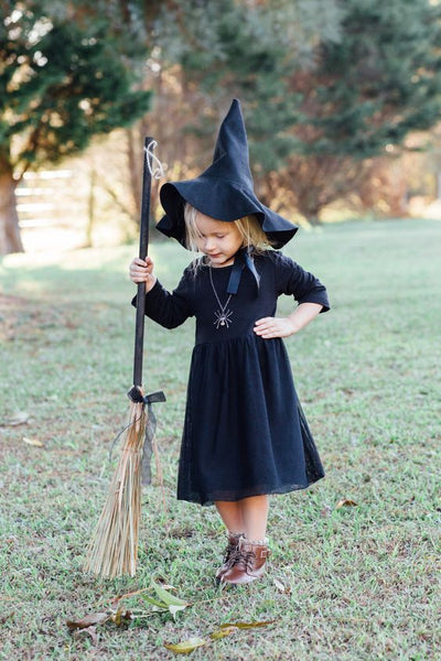 A young girl wearing a DIY witch Halloween costume.