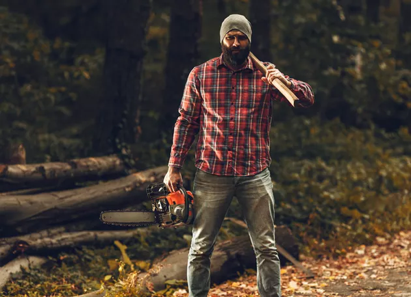 A man wearing an easy lumberjack Halloween costume, featuring a flannel shirt, jeans, and a knit cap.