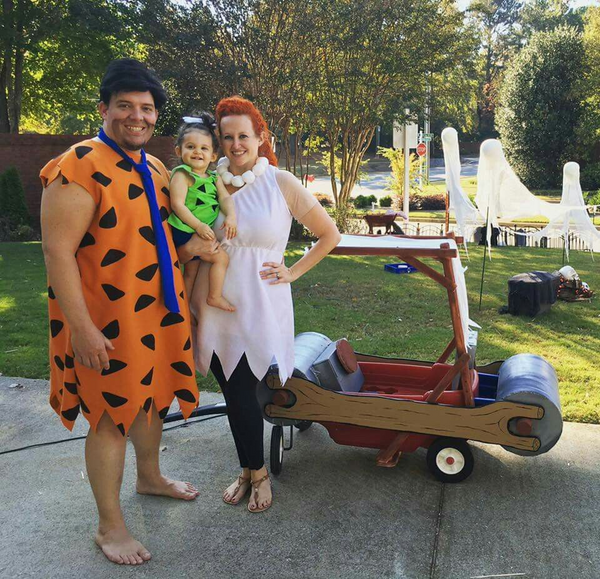 A family dressed in Flinstones Halloween costumes, including Fred, Wanda, and Pebbles.