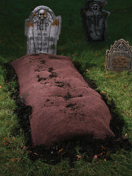 A Halloween decoration that looks like a freshly-dug grave with a headstone.