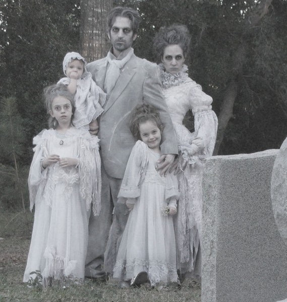 A family of five dressed in an all-white ghost-themed group Halloween costume.