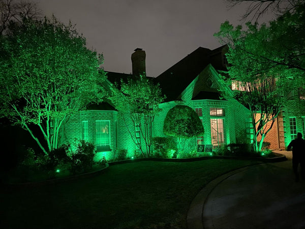 A house tinted green from an LED spotlight projection.