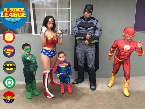 A family dressed in Justice League Halloween costumes, featuring Green Lantern, Wonder Woman, Superman, Batman, and The Flash