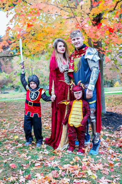 A family dressed in medieval Halloween costumes, include a king, queen, knight, and a dragon.