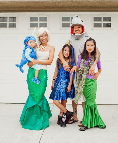 A family dressed in under the sea-themed Halloween costumes, including mermaids and sharks.