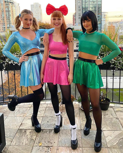 Three women dressed in Halloween costumes as Blossom, Bubbles, and Buttercup from the Powerpuff Girls.