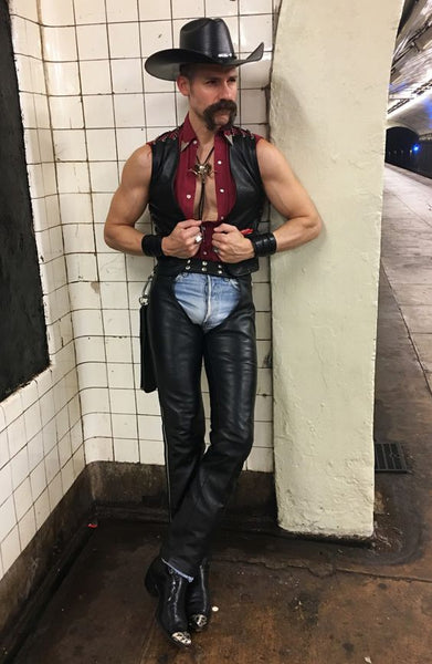 A man dressed in a sexy cowboy Halloween costume.