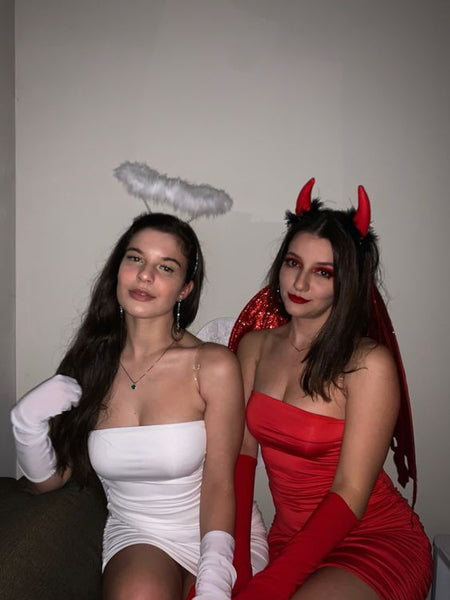 Two women dressed in sexy angel and sexy devil Halloween costumes.
