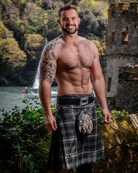 A shirtless man dressed in a sexy kilt Halloween costume.