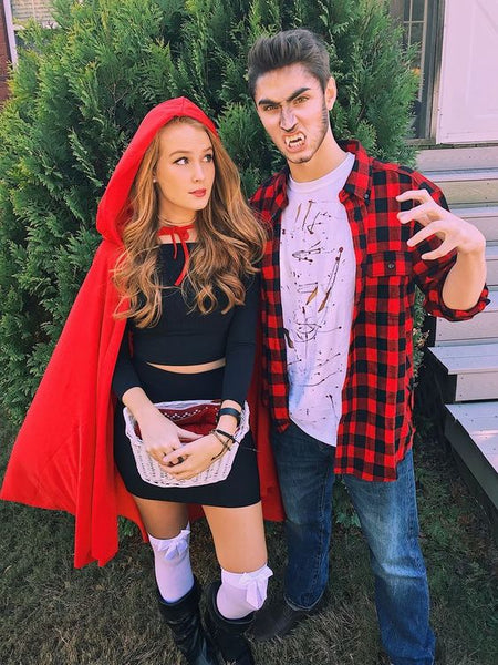 A couple wearing sexy Little Red Riding Hood and Big Bad Wolf Halloween costumes.