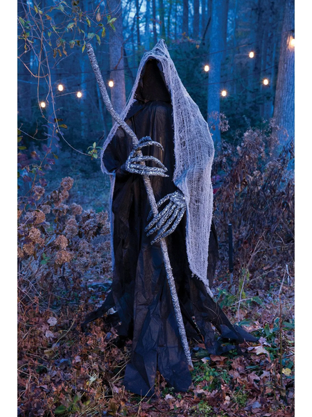 A dark-cloaked reaper with creepy hands and a staff stands menacingly in the woods.