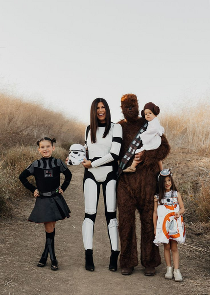 A family dressed in Star Wars Halloween costumes, including Darth Vader, Chewbacca, a Storm Trooper, Princess Leia, and BB-8.