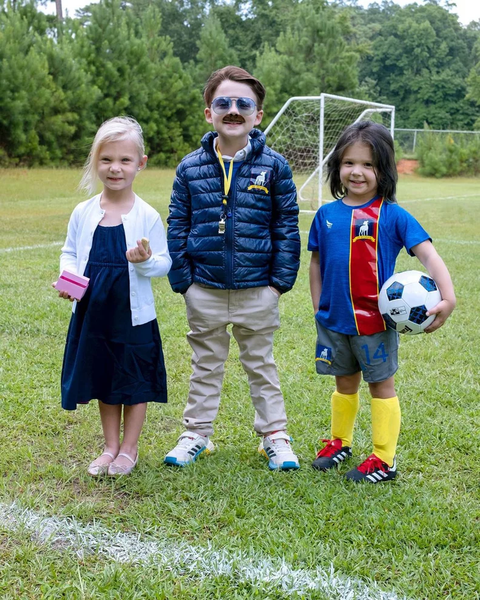 Three children dressed in Ted Lasso Halloween costumes.