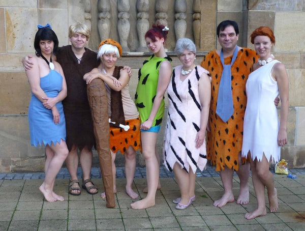 A group of seven people dressed in a Flintstones group Halloween costume.